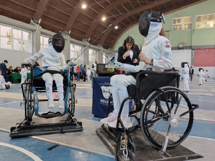 Giovanissimi -atleti olimpici, in carrozzina e bendati, tirano insieme in un torneo di scherma integrata